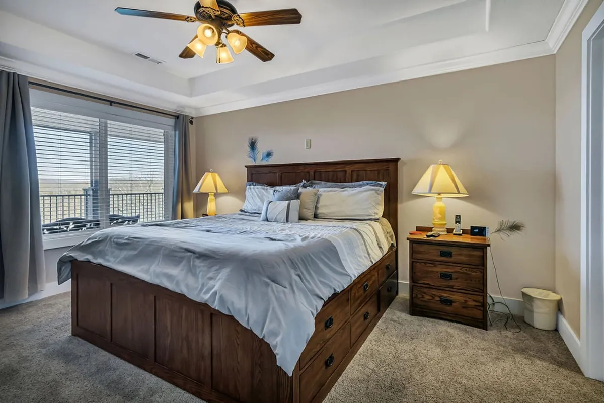 A tranquil bedroom featuring a comfortable bed with crisp linens, a nightstand, and a window that allows natural light to stream in. The decor is understated and relaxing, creating a haven for rest and relaxation.